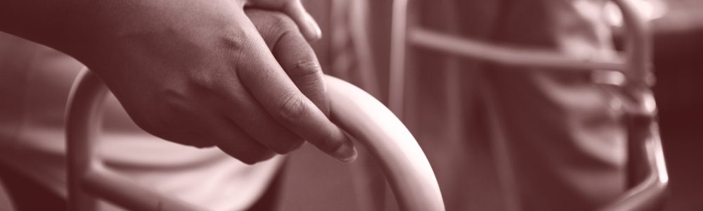 Cropped hands of nurse assisting woman in walking with walker Cropped hands of nurse assisting woman in walking with walker at retirement home