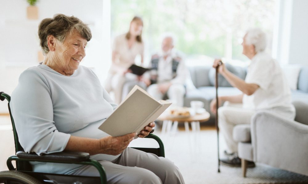 Happy disabled woman reading a book in the nursing home